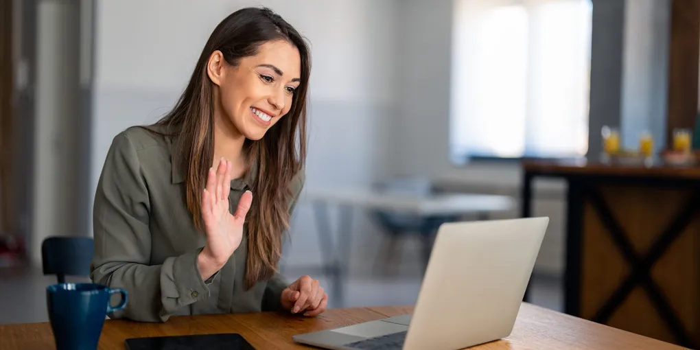 Medewerker werkt thuis achter een laptop met videovergadering op het scherm