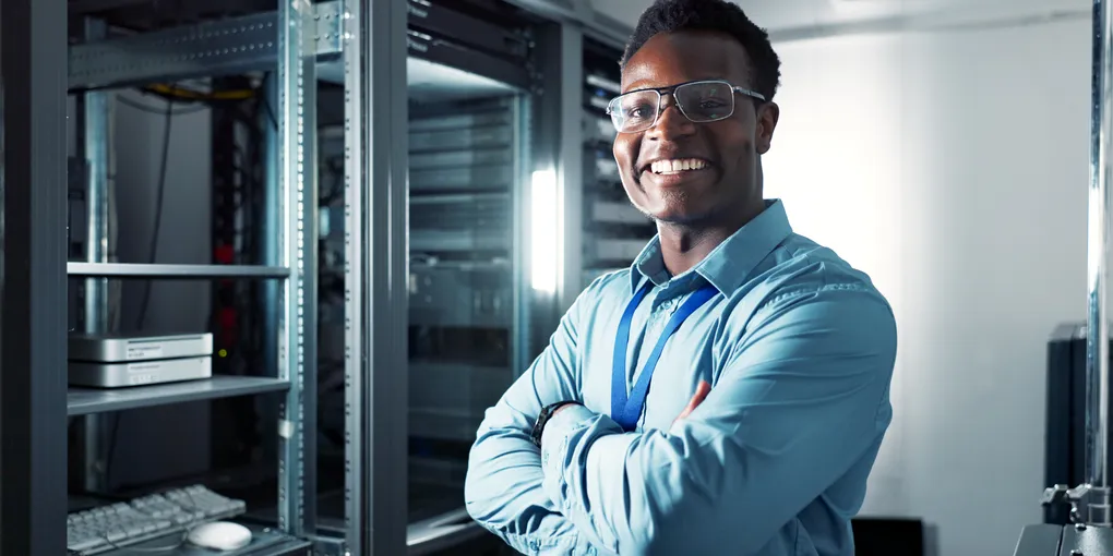Glimlachende IT-engineer in een serverruimte, symbool voor managed IT-services