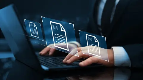 Ondernemer bekijkt cybersecurity-dashboard op laptop met NIS2-documenten op het bureau
